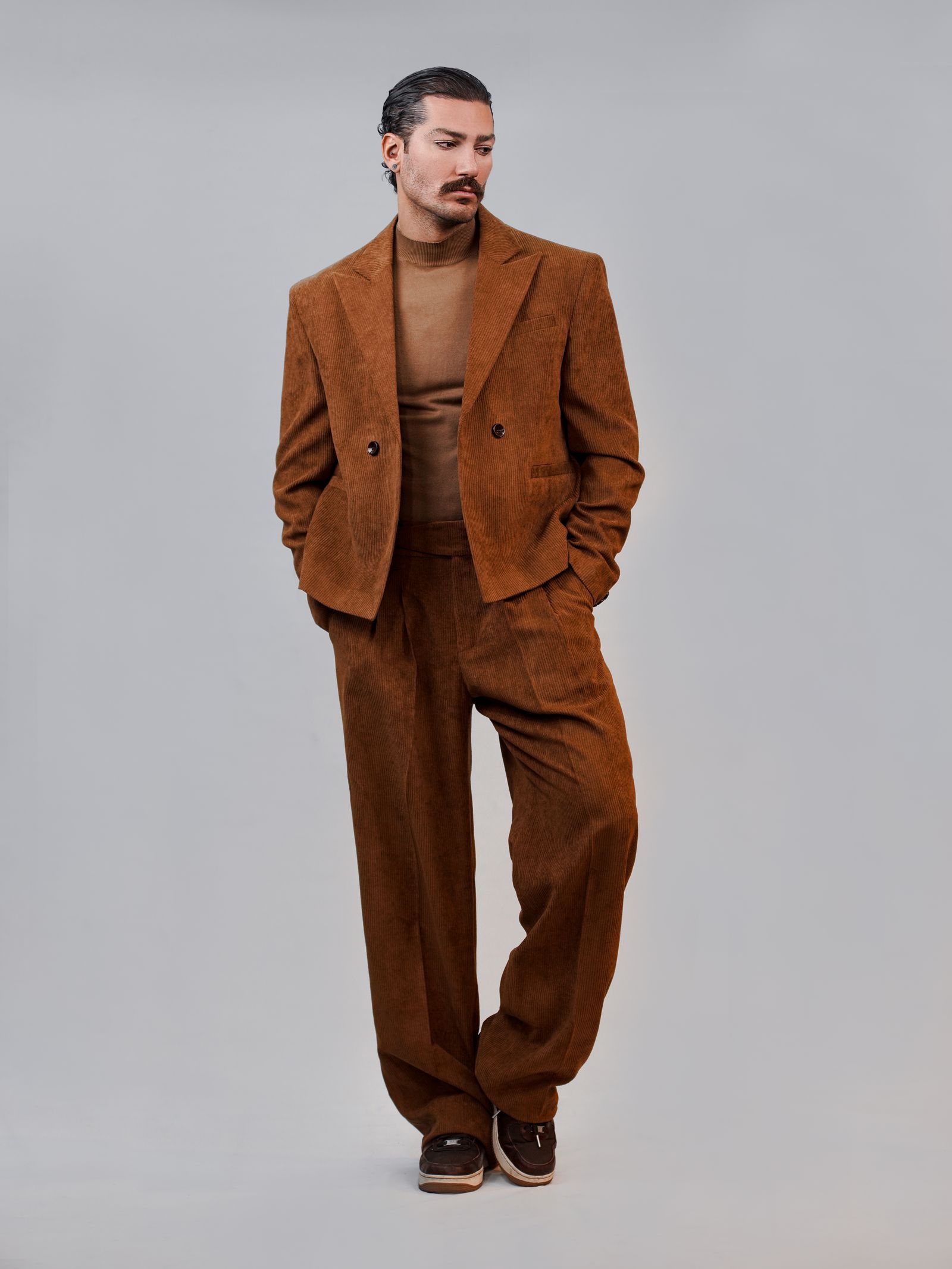 Stylish man in tailored brown suit — capsule wardrobe foundation